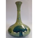 A Moorcroft pottery bottle vase of bulbous form with a long, narrow neck and flared rim,