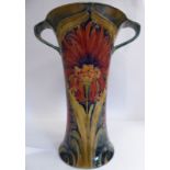 A Moorcroft (for Macintyre) pottery vase of trumpet form with opposing strap handles,