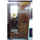 An Edwardian mahogany wardrobe with a mirrored door, a panelled door and three drawers,