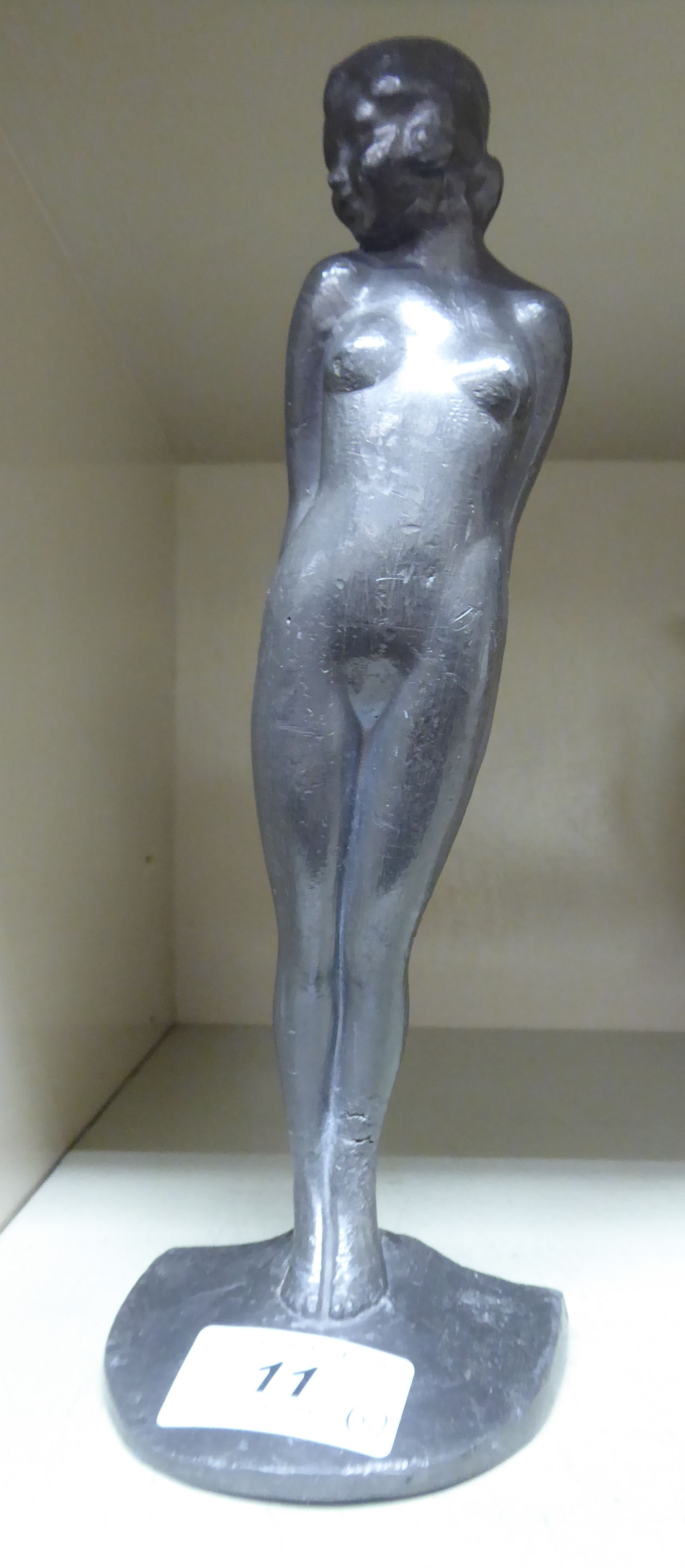 An Art Deco cast lead figure, a standing nude, on a plinth 7.