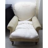 A modern easy chair, upholstered in a cream coloured fabric,