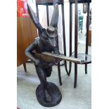 A modern cast and patinated bronze 'hunting hare' holding a double barrel shotgun 34''h CA