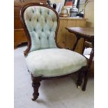 A late Victorian walnut framed, button upholstered spoonback salon chair, raised on turned,