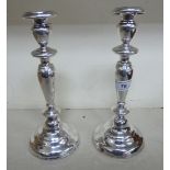 A pair of white metal candlesticks with knopped stems,