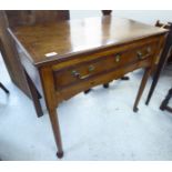 A George III oak lowboy with a single drawer, raised on turned,