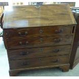 An early 19thC mahogany bureau with a fall flap, over four graduated long drawers,