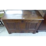 A late 18thC oak mule chest with a hinged lid, tri-panelled front and two base drawers,