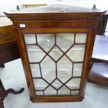 A George III mahogany hanging corner cabinet with a dentil moulded cornice,