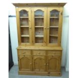 A modern pine dresser with three glazed doors, over three in-line drawers and three panelled doors,