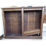 A 1920s carved oak open front bookcase with foliate carved ornament and parallel height adjustable