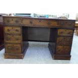 A late Victorian mahogany twin pedestal nine drawer desk,