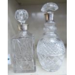 Two crystal decanters, each having a silver collar and stopper,
