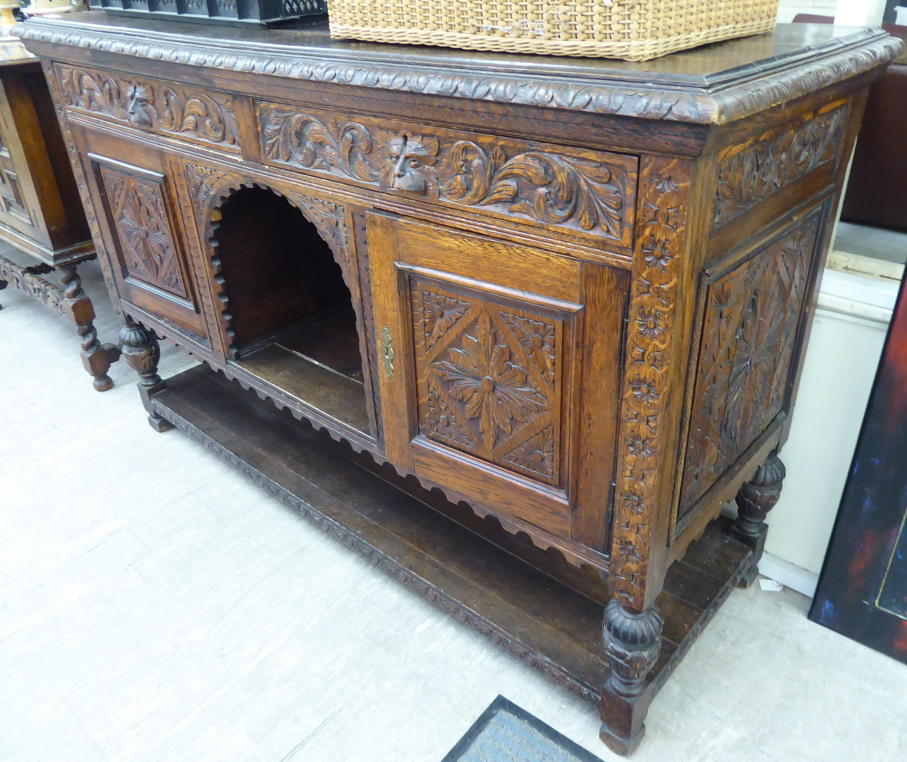 A late Victorian profusely carved oak sideboard, comprising an arrangement of cupboards and doors, - Image 2 of 2