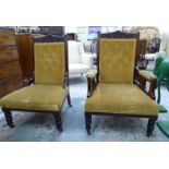 A pair of late Victorian walnut framed salon chairs, upholstered in old gold coloured fabric,