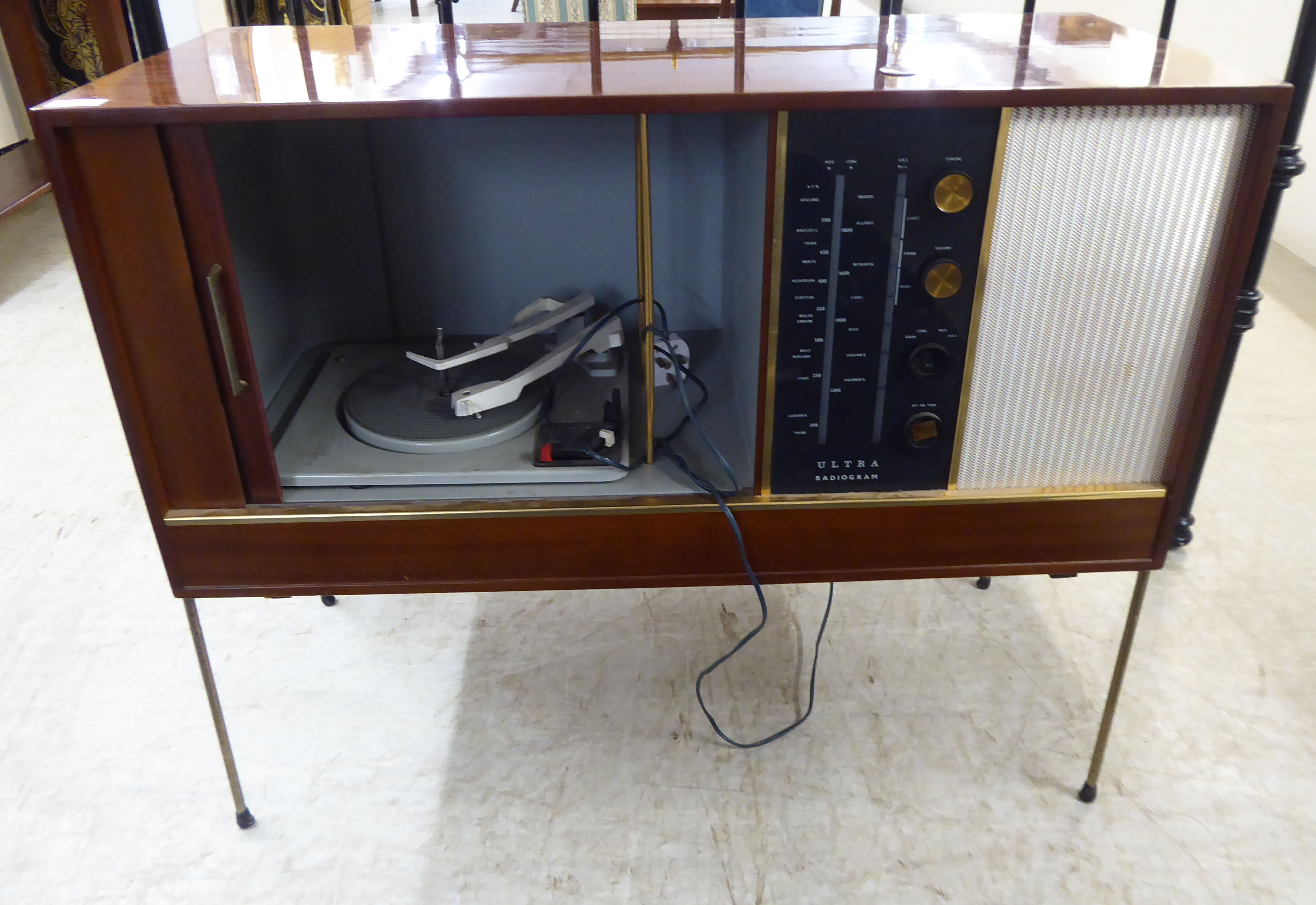 A 'vintage' mahogany finished Ultra radiogram with a sliding door, enclosing a Garrard record deck,