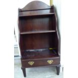 A modern mahogany finished three tier waterfall front bookcase with a base drawer,