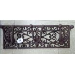 A cast iron coat rack with a pierced backplate and three hooks 17''w CS