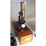 An early 20thC lacquered brass students microscope cased OS1