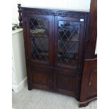 A modern Jaycee oak display cabinet with two lead glazed doors and two linenfold, panelled doors,