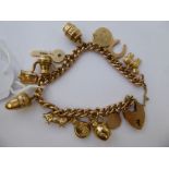 A 9ct gold charm bracelet with twelve pendants 11