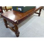 An early 20thC coffee table stool, the studded hide covered top raised on turned mahogany,