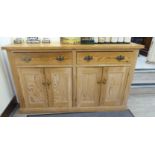 An early 20thC reclaimed waxed pine farmhouse kitchen dresser, comprising two in-line deep drawers,