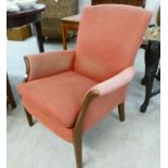 A Parker Knoll pale red fabric upholstered armchair, raised on stained beech,