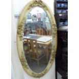 An early 20thC cream painted mirror,