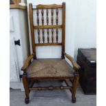An early 19thC honey coloured oak framed low Lancashire side chair with a bobbin turned back, low,