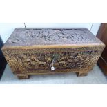 A mid 20thC Chinese camphorwood chest, profusely decorated with ships, figures,