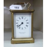 An early 20thC lacquered brass cased carriage timepiece with bevelled glass panels and a folding