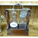 A mid 20thC mahogany table tantalus with silver plated mounts and a lockable bar,