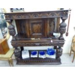 A reproduction of a late Victorian profusely carved and inlaid oak buffet with a platform top over
