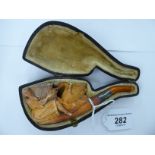 A carved meerschaum and amber cheroot holder with a silver ferrule London 1902,