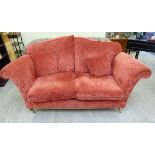 A modern traditionally styled two person settee with scrolled arms,