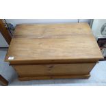A reclaimed stained and waxed pine box with straight sides and a hinged lid,