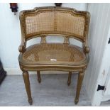 A late 19thC Continental gilt gesso framed salon chair with a caned, panelled back and seat,
