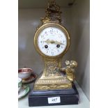 A late 19thC gilt metal cased mantle clock, cast with cherubic figures,