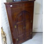 An early 20thC string inlaid mahogany corner cabinet with a pair of panelled doors,