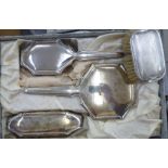 A Continental three piece spot-hammered silver coloured metal mounted dressing table set stamped