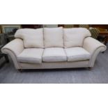 A Welbeck House cream coloured, patterned fabric upholstered three person settee,