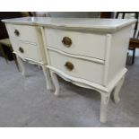A pair of Laura Ashley cream painted serpentine front, two drawer bedside chairs,