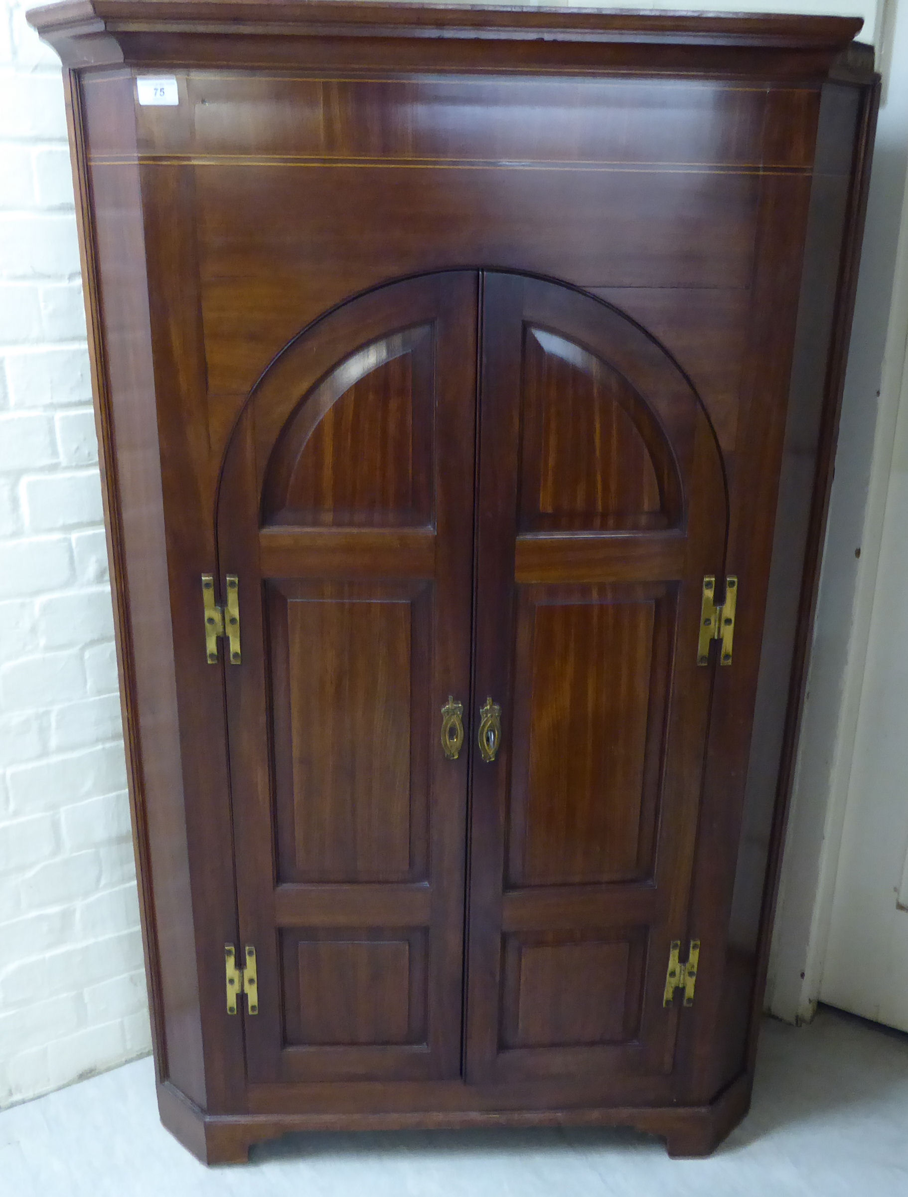 An early 20thC string inlaid mahogany corner cabinet with a pair of panelled doors,