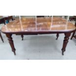 A late Victorian mahogany wind-out dining table, the top with a curved edge, raised on tapered,