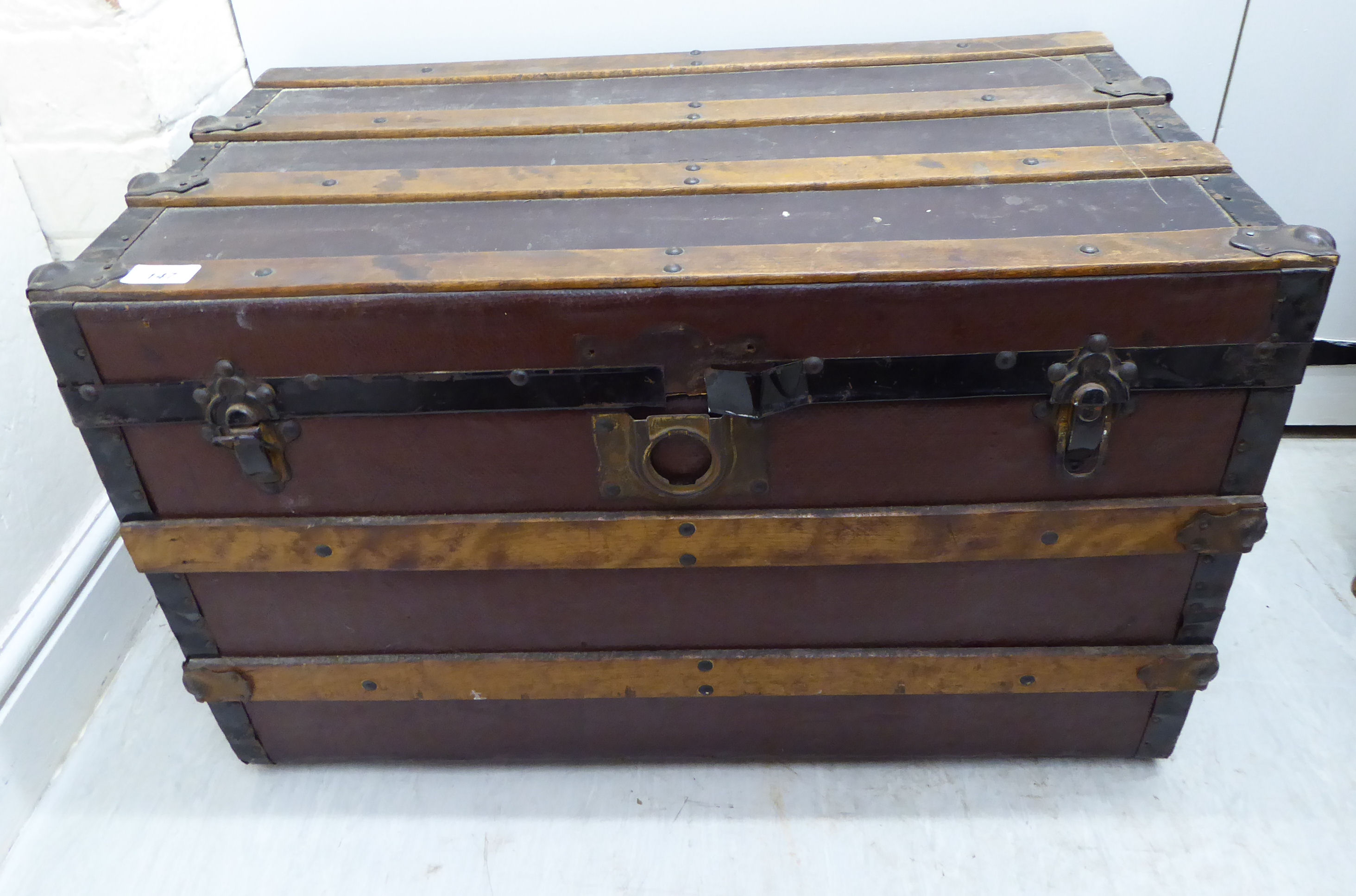 An early 20thC beech bound canvas trunk with straight sides and a hinged lid,