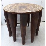 A 20thC African hardwood Nupe stool with a carved sunburst top,