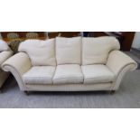 A Welbeck House cream coloured, patterned fabric upholstered three person settee,