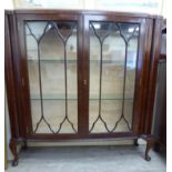 A 1930s walnut veneered display cabinet with two astragal glazed doors,