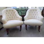 A pair of modern bedroom chairs, part-button upholstered in cream coloured fabric,