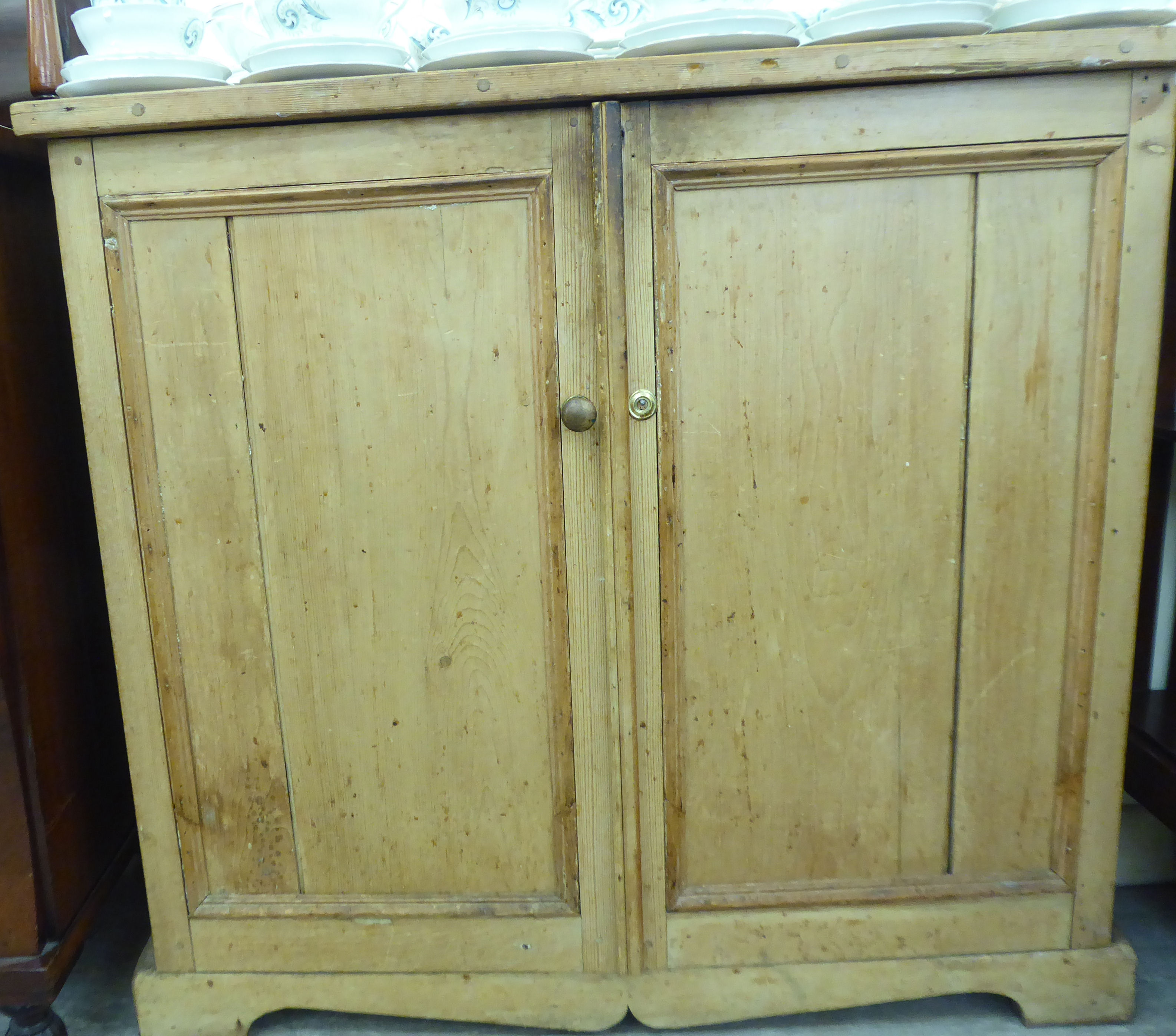 A late Victorian pine two door cabinet,